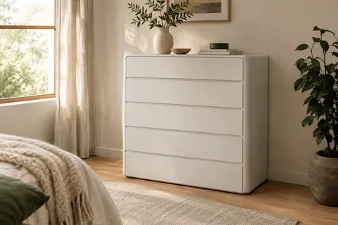 Commode blanche mate Blishom à cinq tiroirs dans une chambre claire au décor chaleureux