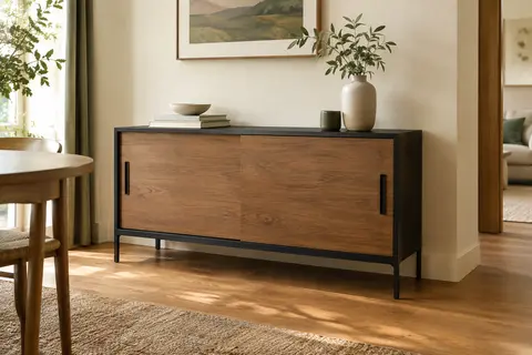 Buffet bas marron camel et noir à deux portes coulissantes, présenté dans une salle à manger chaleureuse.