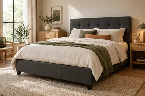 Lit double gris foncé avec tête de lit capitonnée, présenté dans une chambre lumineuse aux matières naturelles.